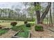 Expansive backyard featuring a wooded area, manicured bushes, and mature shade trees at 220 Carriage Station Dr, Lawrenceville, GA 30046