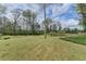 Grassy backyard featuring a manicured lawn and mature trees, offering a serene outdoor space at 220 Carriage Station Dr, Lawrenceville, GA 30046