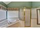 Bathroom featuring a garden tub, shower with glass doors, and a window at 220 Carriage Station Dr, Lawrenceville, GA 30046