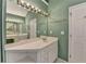 Bright bathroom featuring a long vanity with a built-in desk area and a large mirror at 220 Carriage Station Dr, Lawrenceville, GA 30046