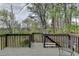 View of spacious, shaded deck with railing and bench overlooking wooded backyard at 220 Carriage Station Dr, Lawrenceville, GA 30046