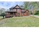 Stately two-story brick home featuring a covered front porch and mature landscaping at 220 Carriage Station Dr, Lawrenceville, GA 30046