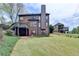 View of the rear exterior of the house with an upper deck and lush lawn at 220 Carriage Station Dr, Lawrenceville, GA 30046