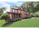 Elegant brick home featuring a welcoming front porch and meticulously manicured landscaping at 220 Carriage Station Dr, Lawrenceville, GA 30046