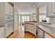 Open kitchen featuring wood floors, white cabinets, modern appliances, and access to the breakfast area at 220 Carriage Station Dr, Lawrenceville, GA 30046