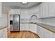 White kitchen cabinets with stainless steel refrigerator and wood flooring at 220 Carriage Station Dr, Lawrenceville, GA 30046
