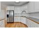 Beautiful kitchen with white cabinets, countertops, stainless fridge, and hardwood floors at 220 Carriage Station Dr, Lawrenceville, GA 30046