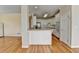 Open concept kitchen with white cabinets and island, stainless appliances, and wood floors at 220 Carriage Station Dr, Lawrenceville, GA 30046