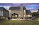 Exterior view of backyard patio with grill, outdoor bar, hot tub, and covered seating area at dusk at 4215 Evans Farms Dr, Cumming, GA 30040