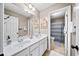 Bright bathroom with double sinks, neutral walls, and a decorative mirror with adjacent toilet and shower at 4215 Evans Farms Dr, Cumming, GA 30040