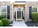 Close-up of the front entrance featuring a glass door, decorative shrubbery and a well-maintained walkway at 4215 Evans Farms Dr, Cumming, GA 30040