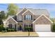 Charming two-story brick home with a well-manicured lawn, attached garage and black shutters at 4215 Evans Farms Dr, Cumming, GA 30040