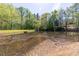 A tranquil pond on a sunny day, surrounded by trees and lush green grass at 4215 Evans Farms Dr, Cumming, GA 30040