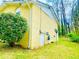 Side view of yellow brick home showing access door, mature landscaping, and outdoor utilities at 4554 Saint Andrews Dr, Atlanta, GA 30331
