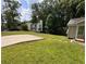 Spacious backyard featuring a well-maintained lawn, mature trees, and a concrete pad for recreation or parking at 1938 Main Nw St, Atlanta, GA 30318