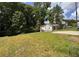 Exterior view of the home with a large, grassy yard and mature trees providing shade and privacy at 1938 Main Nw St, Atlanta, GA 30318