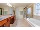 Bright bathroom featuring double sinks, a soaking tub, and a glass-enclosed shower at 2694 Dawning Day Dr, Dacula, GA 30019