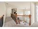 Upstairs hallway overlooking the great room and staircase with wood and wrought iron railing at 2694 Dawning Day Dr, Dacula, GA 30019