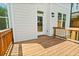 A wooden deck with wood railing next to the back door and surrounded by the siding of the home at 702 Dodd Ln # 159, Buford, GA 30518