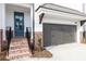 Close up of entrance to new townhome with grey garage and brick steps at 702 Dodd Ln # 159, Buford, GA 30518