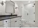 Modern bathroom featuring white vanity, dark countertops, tile shower, and glass door at 100 Maison Ct, Roswell, GA 30076