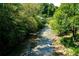 Scenic view of a shallow rocky creek flowing through a lush green forest at 100 Maison Ct, Roswell, GA 30076