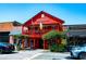 Bright red, two-story building with second story balcony, American and Irish flags, and outdoor seating at 100 Maison Ct, Roswell, GA 30076