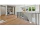 Bright hallway with hardwood floors, black railings, and a built-in bar area with shelving and a beverage cooler at 100 Maison Ct, Roswell, GA 30076