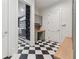 Hallway with laundry room and study featuring black and white checkered tile at 100 Maison Ct, Roswell, GA 30076