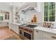 Gourmet kitchen featuring high-end stainless steel appliances and a large window with a wooded view at 100 Maison Ct, Roswell, GA 30076