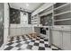 Modern laundry room features black and white checkered floors, cabinets, shelving, and black and gold wallpaper at 100 Maison Ct, Roswell, GA 30076