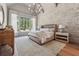 Charming main bedroom with a decorative stone wall, a large window and hardwood flooring at 100 Maison Ct, Roswell, GA 30076