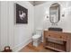 Charming powder room features wood-look floors, board and batten, swan art, and a wooden vanity with a dark countertop at 100 Maison Ct, Roswell, GA 30076