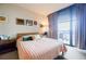 A well-lit main bedroom offers cozy decor, plush bedding, and convenient access to a private balcony at 1130 Piedmont Ne Ave # 1407, Atlanta, GA 30309