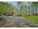 Gravel driveway in front of the home with mature trees at 3541 Hutcheson Ferry Rd, Whitesburg, GA 30185