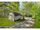 View of storage building with driveway through wooded lot at 3541 Hutcheson Ferry Rd, Whitesburg, GA 30185