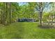 Far view of the home showing the lawn, trees and outbuildings at 3541 Hutcheson Ferry Rd, Whitesburg, GA 30185