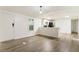Living room with laminate wood floors, open to kitchen, and white walls at 3541 Hutcheson Ferry Rd, Whitesburg, GA 30185