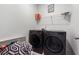 Laundry room featuring a modern, front-loading washer and dryer with storage shelves at 4143 Halton Rd, Duluth, GA 30097