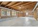 Unfinished basement showcasing the exposed beams, concrete floor, and three windows for natural light at 2060 Pate Ridge Dr, Loganville, GA 30052