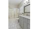 Charming bathroom featuring gray vanity, shower-tub combo, white marbled floors, and natural light at 2060 Pate Ridge Dr, Loganville, GA 30052