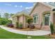 Close up showing a brick home's arched entryway, manicured garden beds, and pristine lawn at 2060 Pate Ridge Dr, Loganville, GA 30052