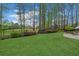 Beautifully landscaped backyard with green lawn, mature trees, and wrought iron fence at 2305 Whiting Bay Cts, Kennesaw, GA 30152