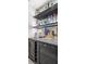 Stylish bar with dark cabinets, granite countertop, and mirrored backsplash with open shelving at 2305 Whiting Bay Cts, Kennesaw, GA 30152