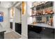 Elegant bar with custom cabinetry, stylish lighting, mirrored backsplash, and open shelving for bottles at 2305 Whiting Bay Cts, Kennesaw, GA 30152