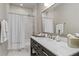 Modern bathroom features elegant tile work, updated vanity, and shower with curtain at 2305 Whiting Bay Cts, Kennesaw, GA 30152