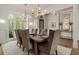 Elegant dining room with a large wooden table, upholstered chairs, and stylish chandelier at 2305 Whiting Bay Cts, Kennesaw, GA 30152