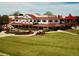 Expansive exterior view featuring lush green lawns, outdoor patio seating, and a red roof at 2305 Whiting Bay Cts, Kennesaw, GA 30152