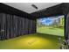 Golf simulator room with a large screen, turf flooring, and golf equipment at 2305 Whiting Bay Cts, Kennesaw, GA 30152