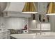 Bright kitchen features stainless steel appliances, white cabinets, marble countertops, and a herringbone backsplash at 2305 Whiting Bay Cts, Kennesaw, GA 30152